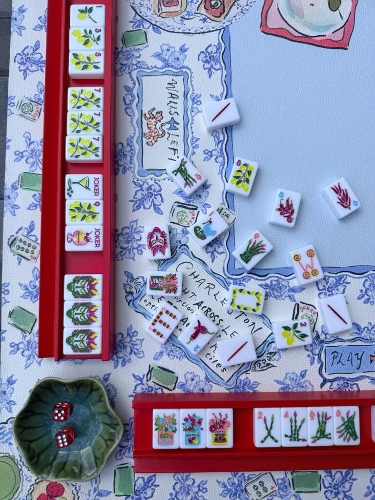 A Charleston in progress on a blue floral mat, with red racks and red dice in a green flower dish