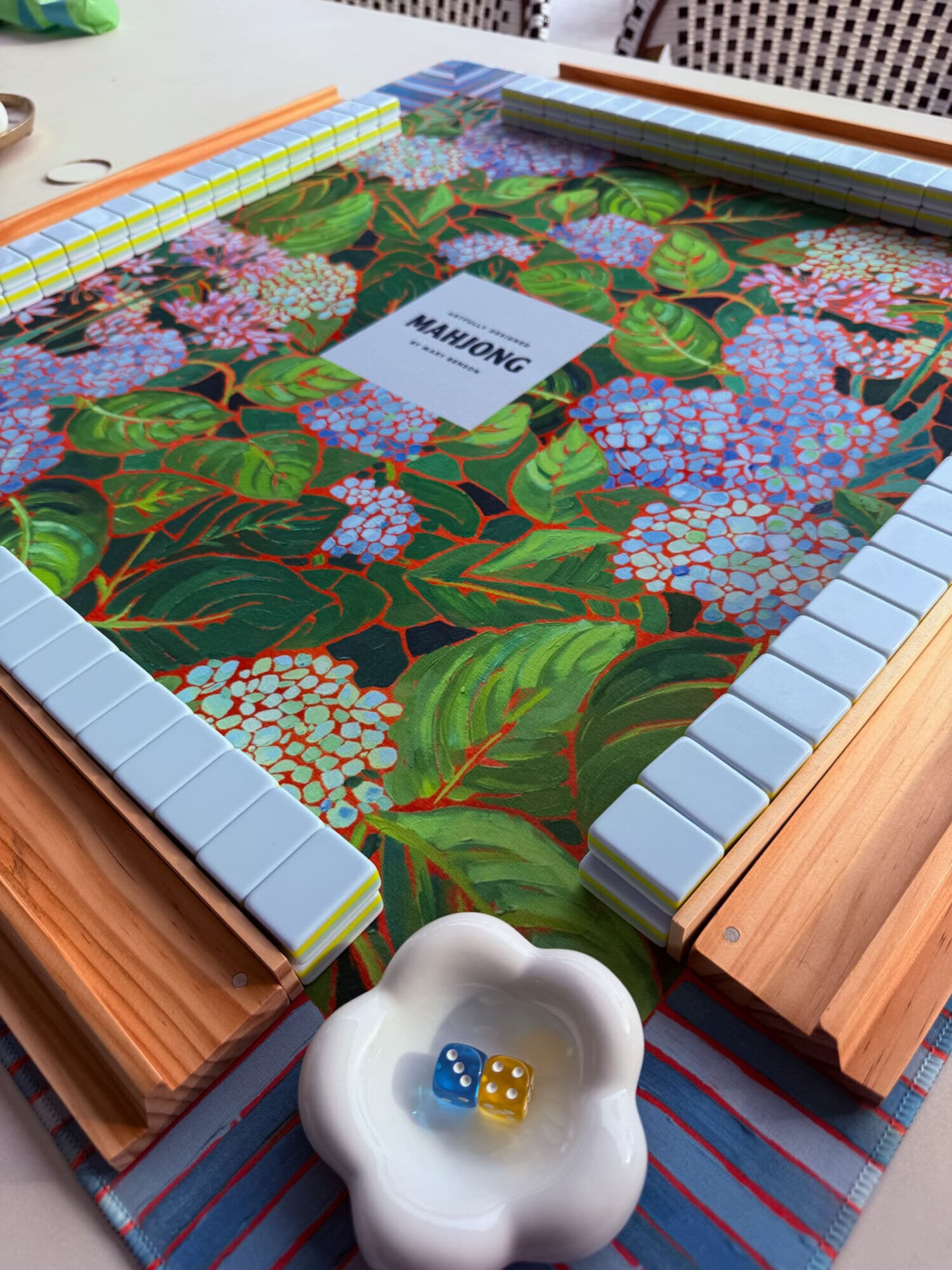 A fresh wall of pale blue tiles in wooden racks on a painted hydrangea mat